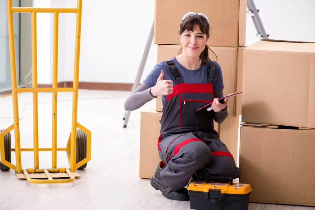 A woman contractor with cardboard boxes in the concept of house move