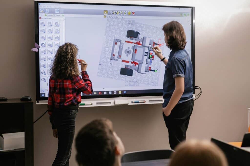 A teacher and student presenting in front of the class