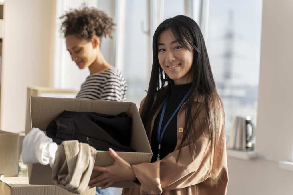 Two female students unpacking boxes after the move